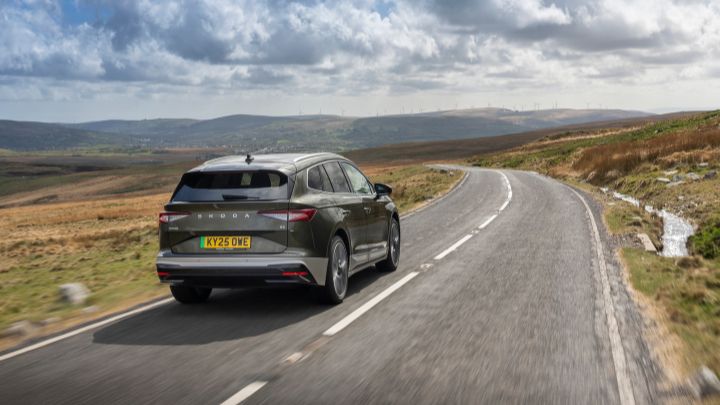 Grey Skoda Enyaq driving in mountains rear